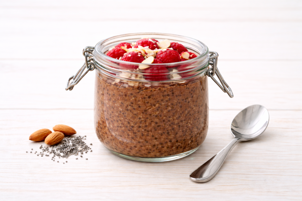 Chia pudding chocolat en bocal avec framboises, amandes et graines de chia