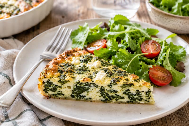 Quiche protéinée sans pâte aux épinards et feta avec salade verte et tomates cerises